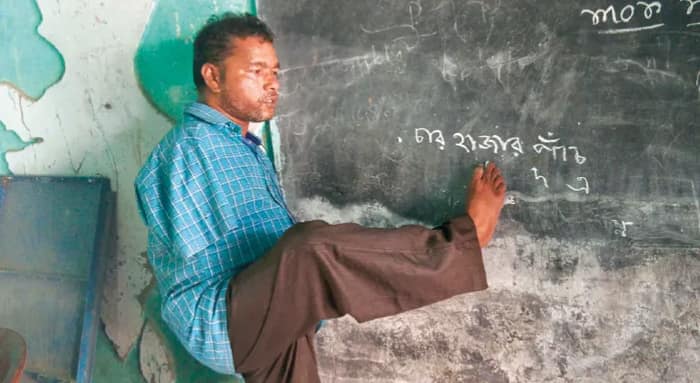 দুই হাত নেই, পা দিয়ে লিখে ছাত্রদের আলো দেখান আউশগ্রামের জগন্নাথ