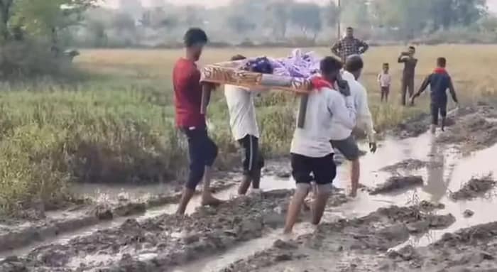 রাস্তা খারাপ, খাটে চাপিয়ে অসুস্থ বৃদ্ধাকে ফিরিয়ে আনা হল বাড়িতে