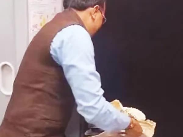 চলন্ত ট্রেন থেকে খাবারের উচ্ছিষ্ট ফেলছেন রেলকর্মীই